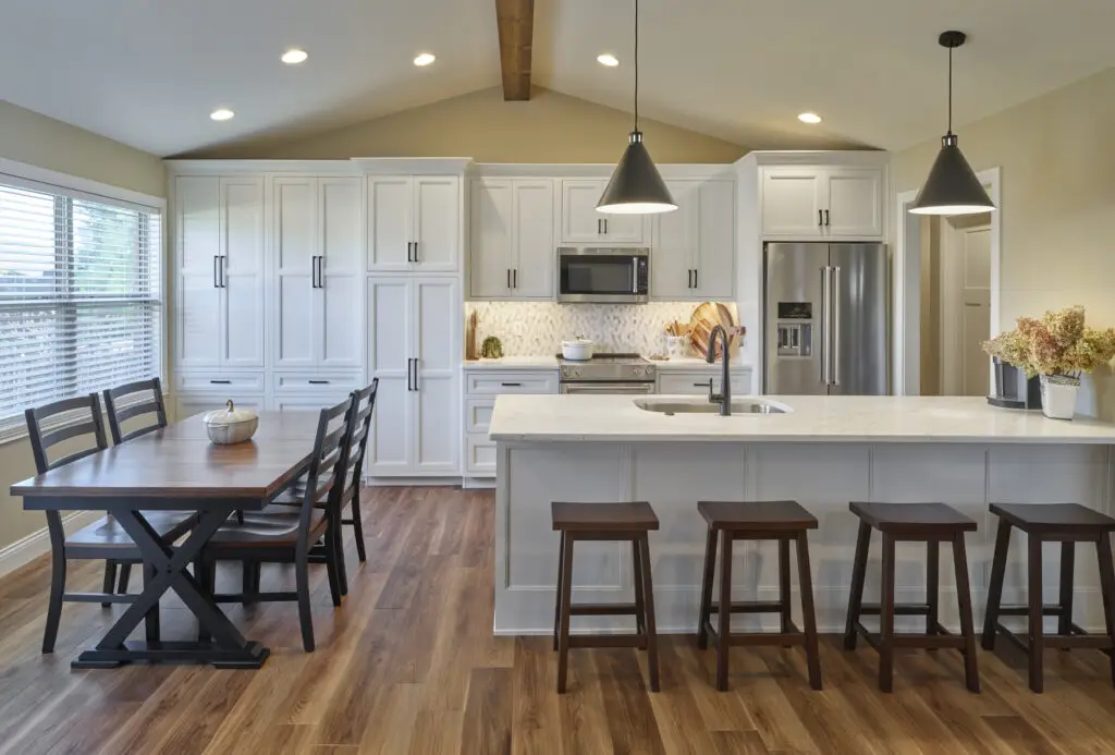 home kitchen with diner table and white wooden cabinets.